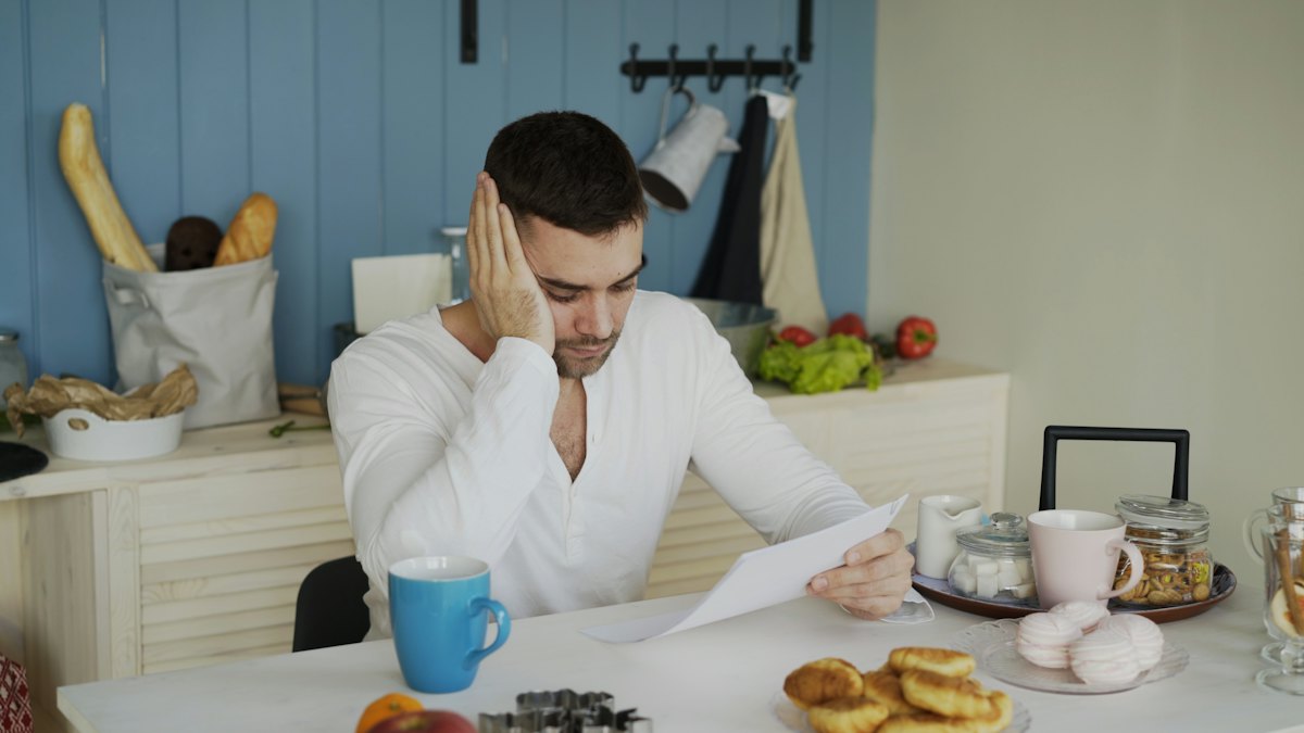 Homem preocupado analisando contas e documentos