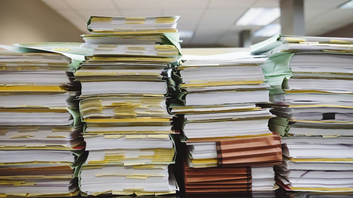 Pilhas de processos e documentos em arquivo